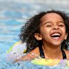 Little girl swimming in a pool and laughing