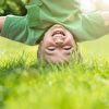 Boy in Green Doing Headstand on Grass