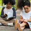 Girl and Boy Sitting on Wooden Pavement While Reading