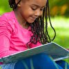 Girl in Pink Reading Book by the Tree