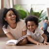 Mother and Son Laughing Together With Book